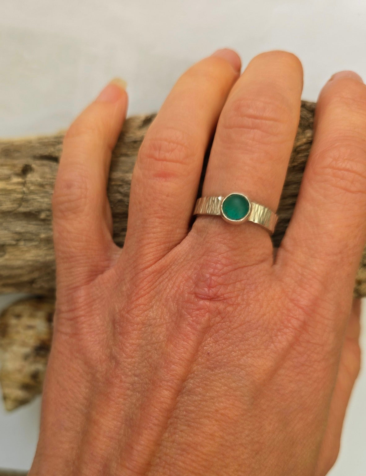 Green sea glass ring in recycled sterling silver with a textured adjustable band